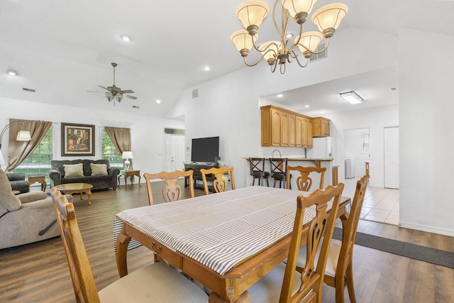 dining room with visible vents, wood finished floors, high vaulted ceiling, recessed lighting, and ceiling fan with notable chandelier