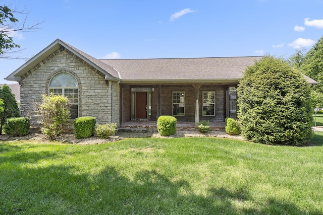 ranch-style home with a porch, a front lawn, roof with shingles, and stone siding