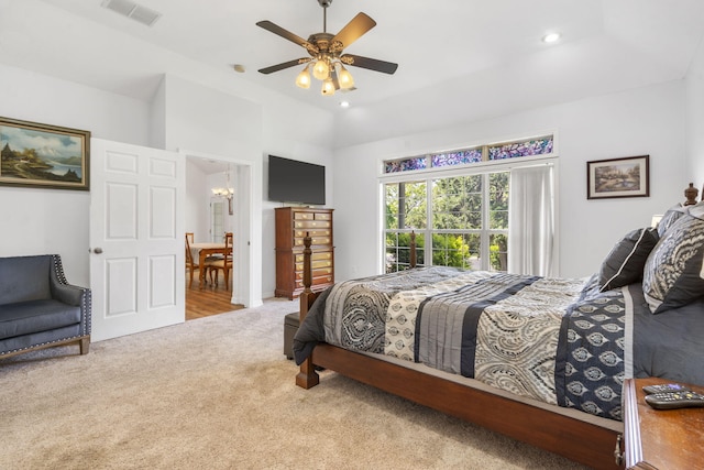 carpeted bedroom featuring ceiling fan with notable chandelier, vaulted ceiling, recessed lighting, and visible vents