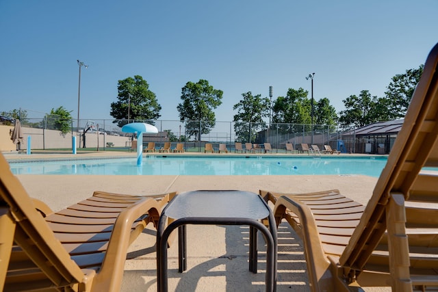 pool with a patio area and fence