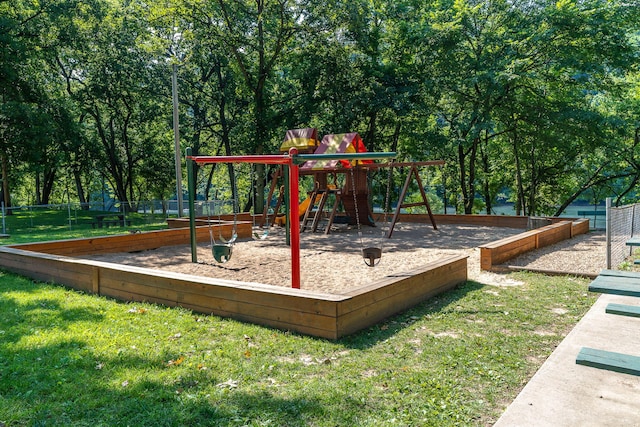 community play area featuring a lawn and fence