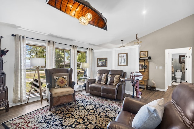 living room featuring baseboards, wood finished floors, and lofted ceiling