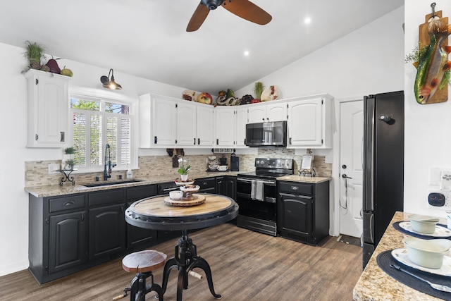 kitchen with freestanding refrigerator, electric range oven, stainless steel microwave, white cabinetry, and a sink