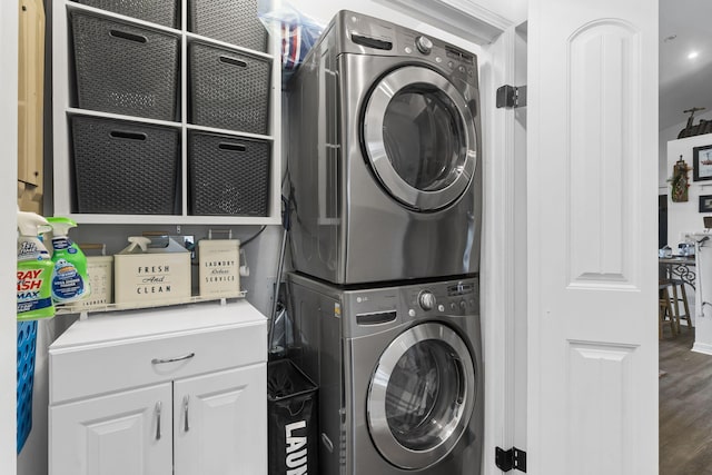 laundry area featuring laundry area, stacked washer / dryer, and wood finished floors