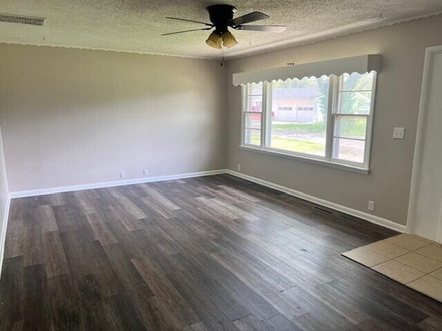 spare room with ceiling fan, dark wood-style floors, a textured ceiling, and visible vents