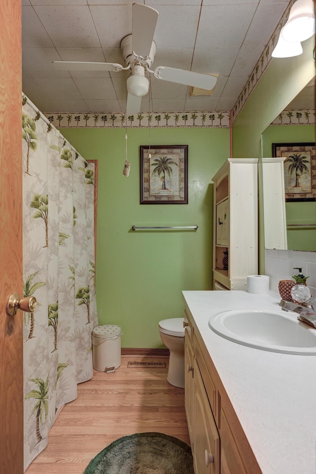 3623 Ridge Dr, Joplin, MO 64801 - bathroom with vanity, toilet, a ceiling fan, curtained shower, and wood finished floors