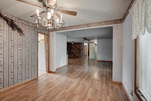 3623 Ridge Dr, Joplin, MO 64801 - spare room with ceiling fan with notable chandelier, a textured ceiling, and wood finished floors