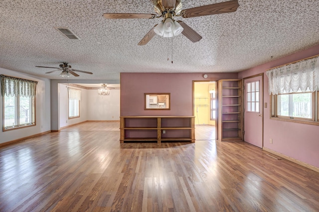 3623 Ridge Dr, Joplin, MO 64801 - unfurnished living room with a healthy amount of sunlight, a textured ceiling, ceiling fan, and wood finished floors