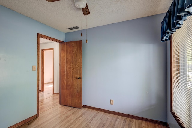 3623 Ridge Dr, Joplin, MO 64801 - unfurnished bedroom with baseboards, light wood finished floors, a textured ceiling, and visible vents