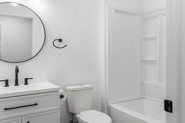 bathroom featuring toilet, a textured wall, and vanity