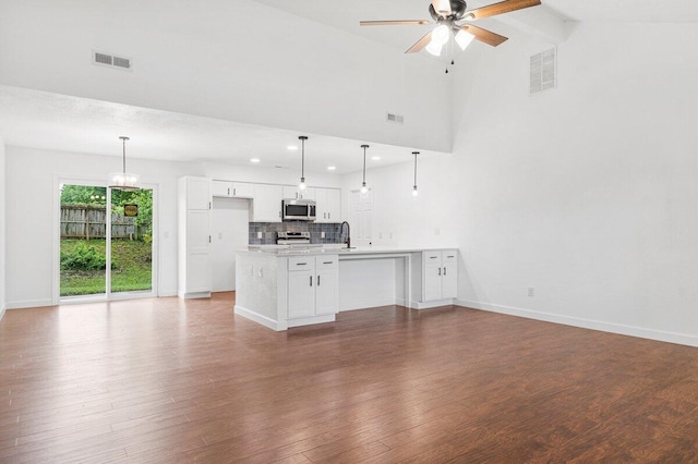 unfurnished living room with visible vents, a sink, baseboards, and ceiling fan