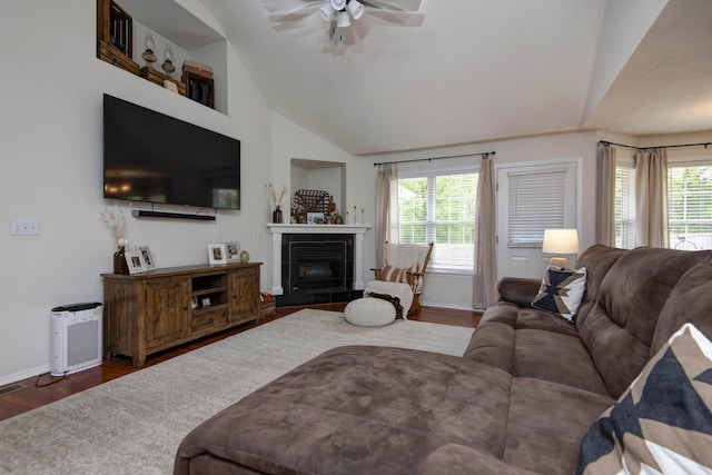 living area featuring baseboards, ceiling fan, wood finished floors, and a wealth of natural light