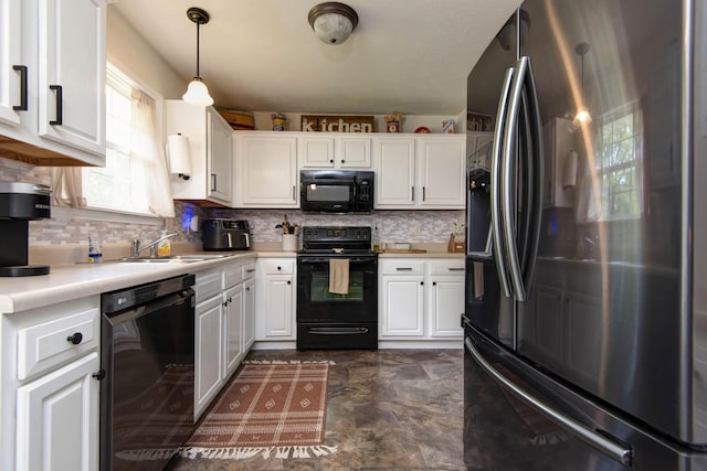 kitchen with a sink, light countertops, white cabinetry, backsplash, and black appliances