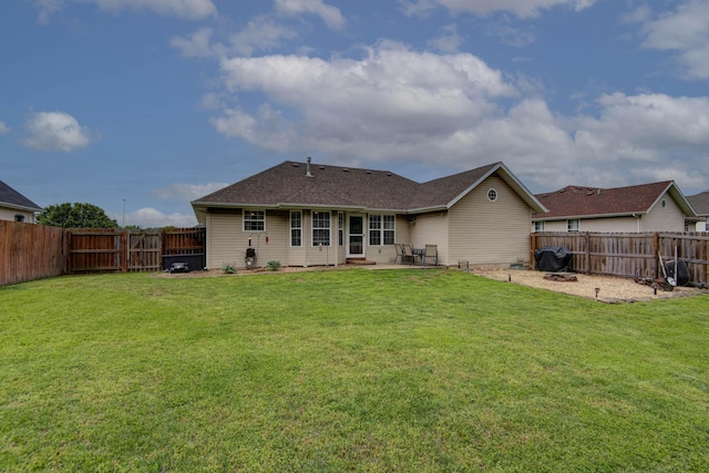 back of property with a patio, a fenced backyard, and a lawn