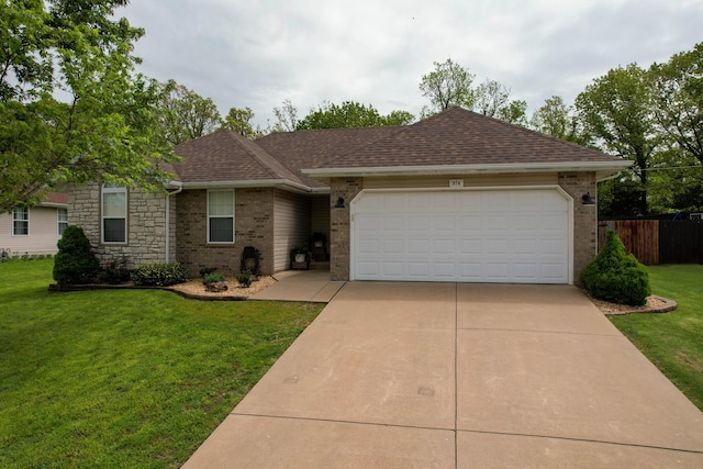 ranch-style house featuring fence, an attached garage, brick siding, a front yard, and driveway