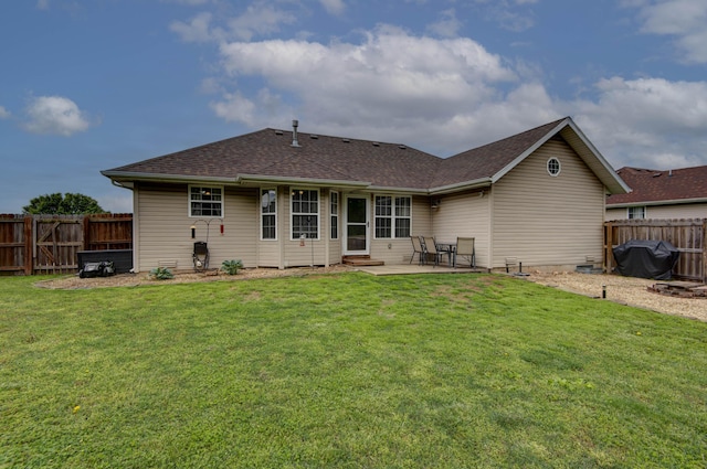 rear view of house featuring a fenced backyard, a patio, a shingled roof, and a lawn