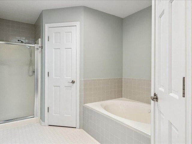 bathroom featuring tile patterned floors, a garden tub, and a stall shower