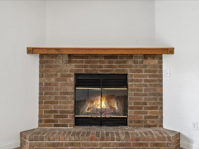 interior details with baseboards and a fireplace