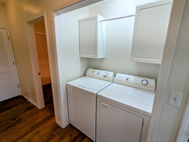laundry area featuring dark wood-type flooring, cabinet space, and washing machine and clothes dryer