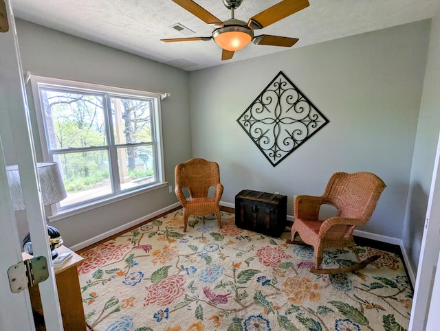 sitting room featuring baseboards, a ceiling fan, and visible vents