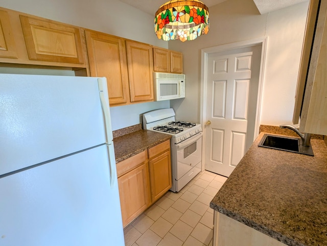 kitchen featuring dark countertops, a sink, light brown cabinets, white appliances, and light tile patterned floors