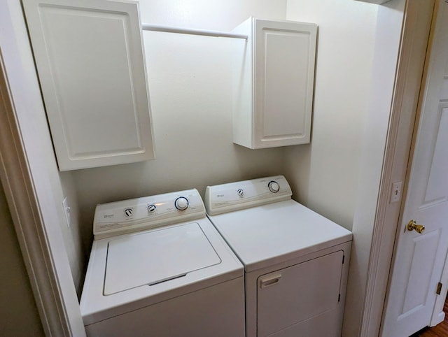 laundry area with separate washer and dryer and cabinet space