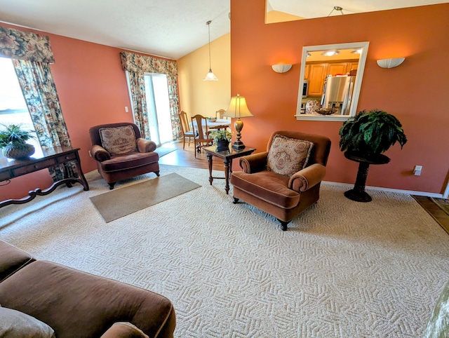 carpeted living room featuring baseboards and vaulted ceiling