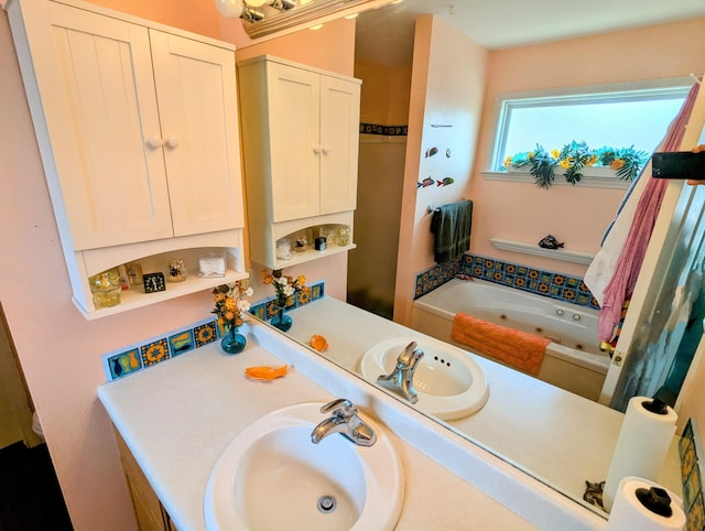bathroom with a tub with jets and vanity