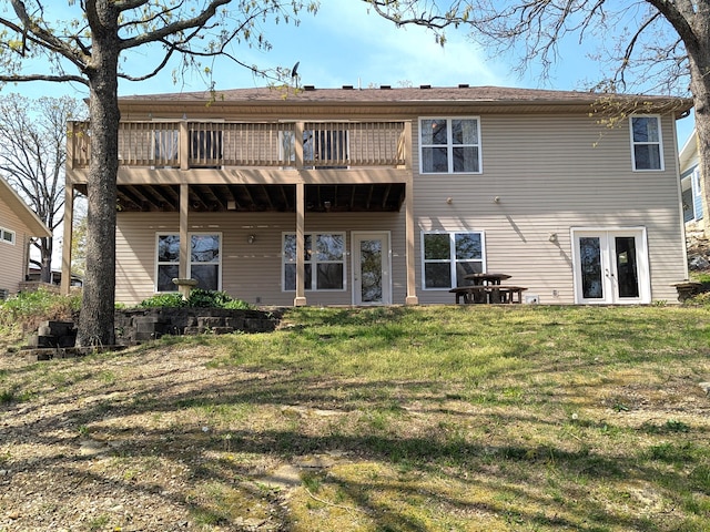 rear view of house with a lawn, a wooden deck, and french doors