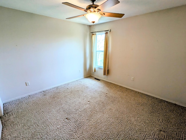 carpeted empty room with baseboards, ceiling fan, and visible vents
