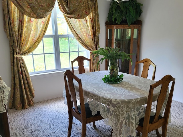 carpeted dining room with baseboards