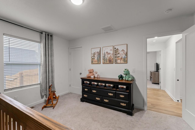 bedroom with baseboards, light carpet, and visible vents