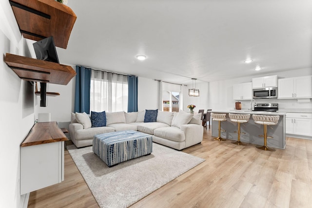 living area with light wood-type flooring and recessed lighting