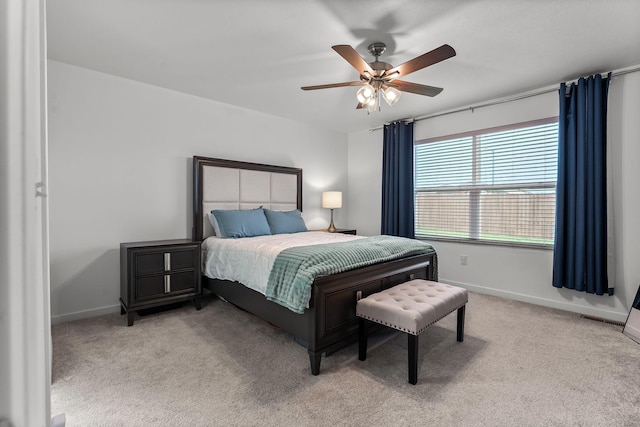 bedroom featuring light colored carpet, baseboards, ceiling fan, and visible vents