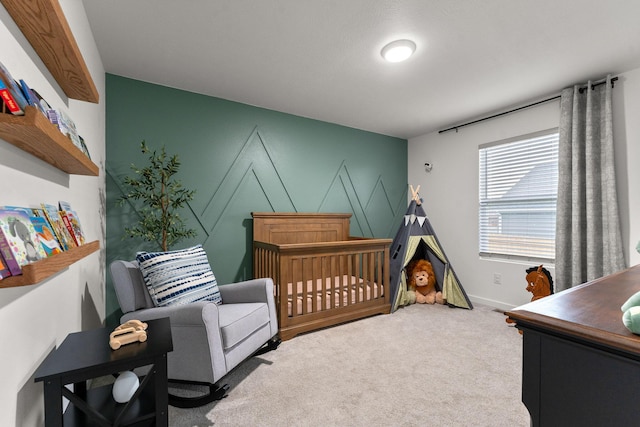 bedroom featuring carpet floors, a crib, and baseboards