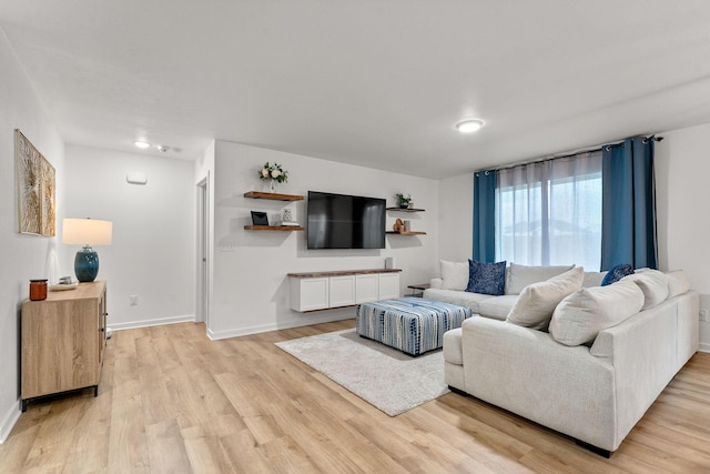 living area featuring light wood-style floors and baseboards