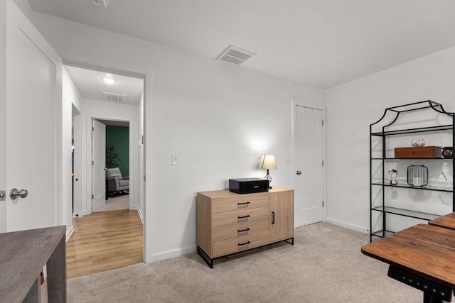office with baseboards, light colored carpet, and visible vents