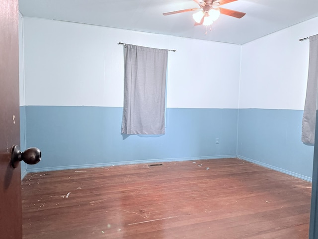 unfurnished room with baseboards, ceiling fan, visible vents, and wood finished floors
