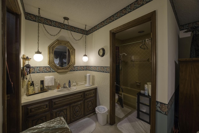 bathroom with vanity, a textured ceiling, washtub / shower combination, and toilet
