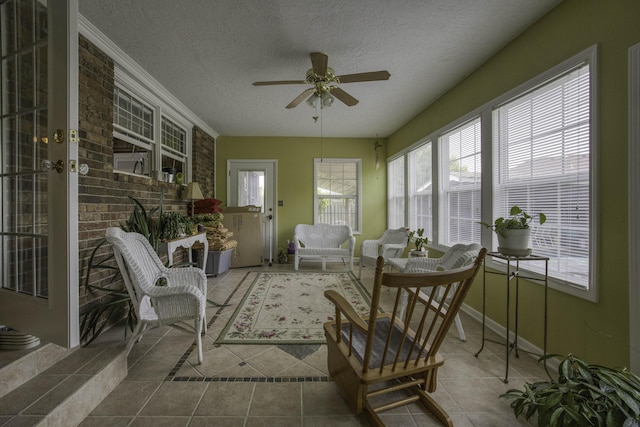 sunroom with baseboards, a textured ceiling, and tile patterned floors