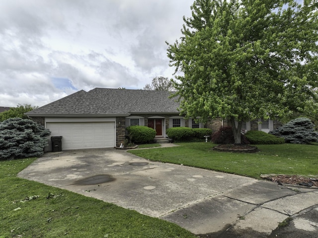 ranch-style home featuring an attached garage, a shingled roof, a front yard, and concrete driveway