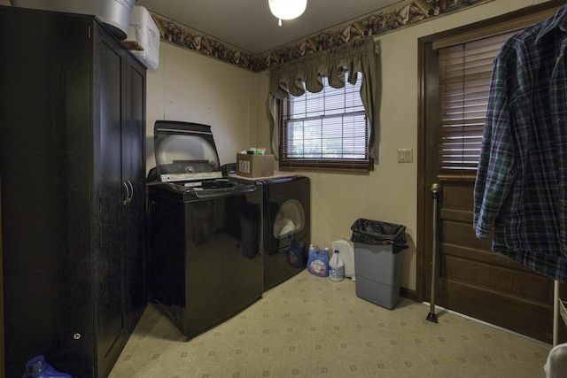 clothes washing area featuring light floors, cabinet space, and washer and dryer