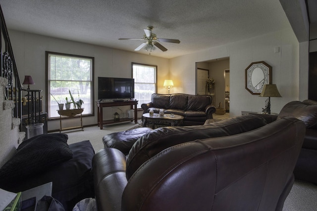 carpeted living room featuring a ceiling fan and a textured ceiling