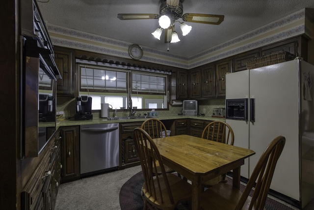kitchen with dark brown cabinets, ceiling fan, light colored carpet, white fridge with ice dispenser, and stainless steel dishwasher