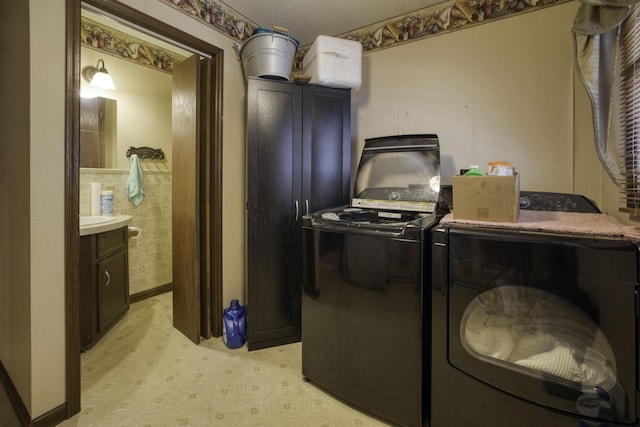 laundry area with light floors, laundry area, and washer and clothes dryer