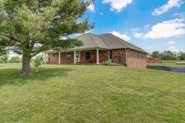 view of property exterior with a yard, brick siding, and covered porch