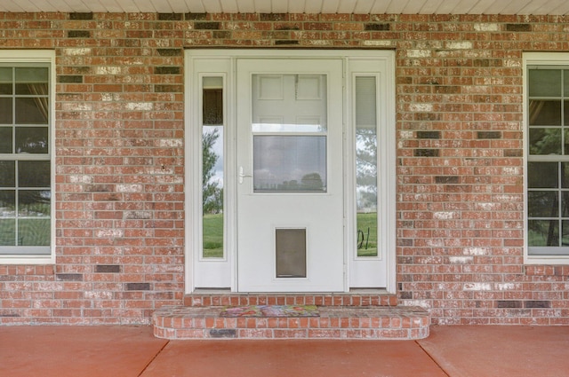 view of exterior entry featuring brick siding