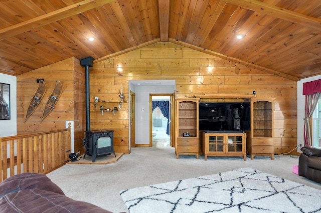 carpeted living room with wooden walls, wooden ceiling, vaulted ceiling with beams, and a wood stove