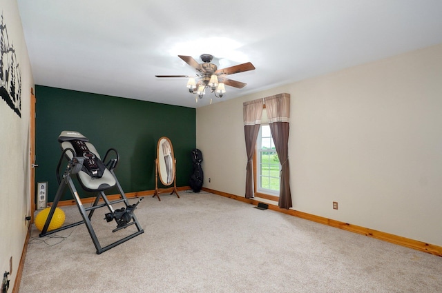 workout room with baseboards, light carpet, and a ceiling fan