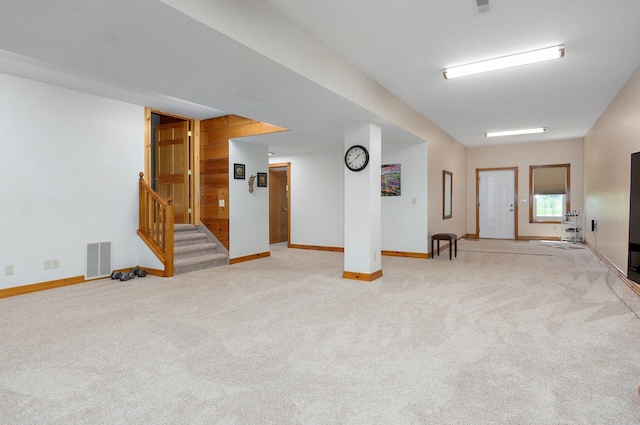 unfurnished room featuring baseboards, light carpet, visible vents, and stairway